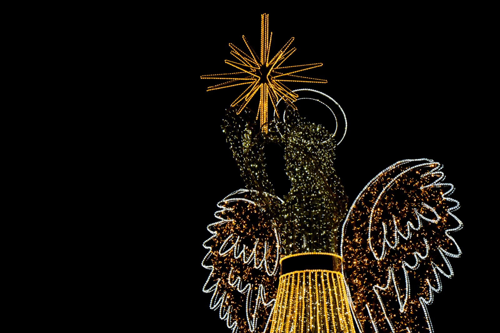 One of Marbella's illuminated Christmas angel figures against the night sky
