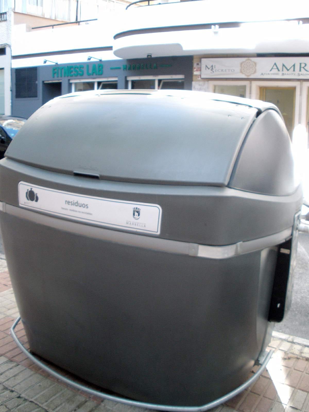 A municipal recycling container on a Marbella street, marked Ayto. Marbella