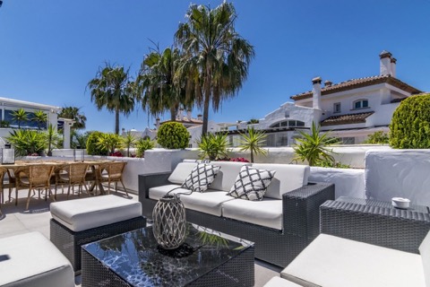 Roof terrace of a La Rada apartment on the San Pedro de Alcántara seafront, with the development's white townhouses behind